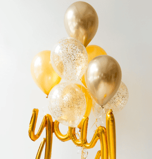 Gold balloons with glittery accents and a 'Happy Birthday' banner on a light gray background